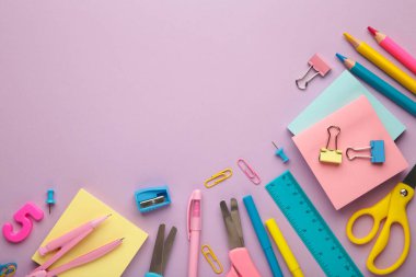 Different stationery on purple background, flat lay with space for text.