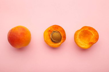 Pembe arka planda taze kayısılar, üst manzara.