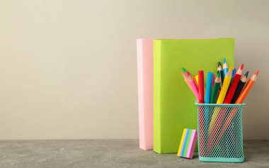 School accessories with books on grey background. Back to school concept. Space for text