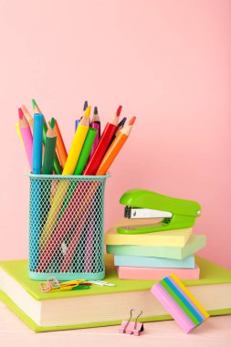 School accessories with books on pink background. Back to school concept. Space for text
