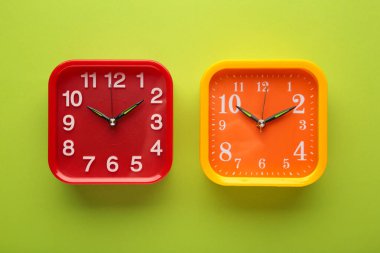 Yeşil arka planda pembe ve kırmızı duvar saati. Üst görünüm