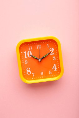 Pembe arka planda sarı alarm saati ve kopyalama alanı. Üst görünüm