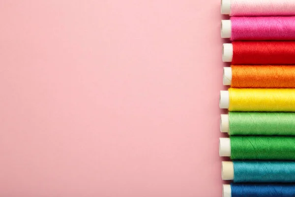 Farbige Nähfäden Auf Rosa Hintergrund Raum Für Text Ansicht Von — Stockfoto