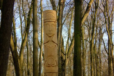 Parktaki bir putperestin tapınağı. Tahtadan heykeller, ormanda bir tapınak.