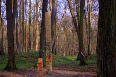 Parktaki bir putperestin tapınağı. Tahtadan heykeller, ormanda bir tapınak.