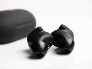 Bir çift siyah kablosuz kulaklık ve beyaz izole bir arka plan.