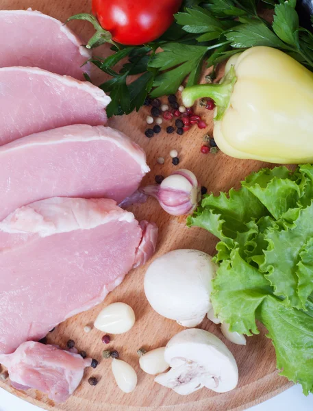肉を調理します。木の板に野菜と豚肉. — ストック写真