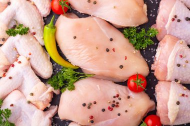 Çiğ tavuk göğsü (fileto), baharat ve bitkilerle kanat ve bacak çeşitleri. Aşçılık arkaplanı