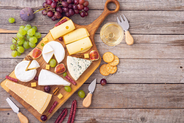 Cheese board with fruits and snack . delicatessen food background