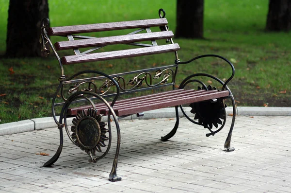 Metal forged bench in autumn park — Stock Photo, Image