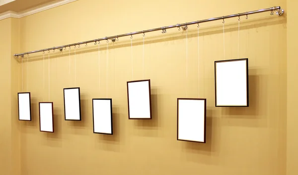 Seven frames with isolated canvas on the exhibition ledge — Stock Photo, Image