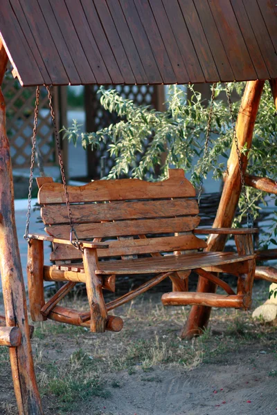 Wooden chain swing in a bench under a canopy — Stock Photo, Image