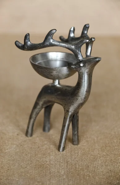 Vintage metal stand-candlestick in the form of a deer with a bow — Stock Photo, Image