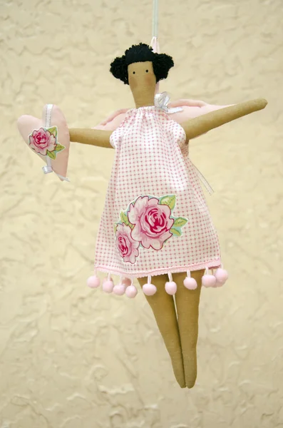 Kanatları ve elinde kalp ile atış elbiseli el yapımı oyuncak bebek — Stok fotoğraf
