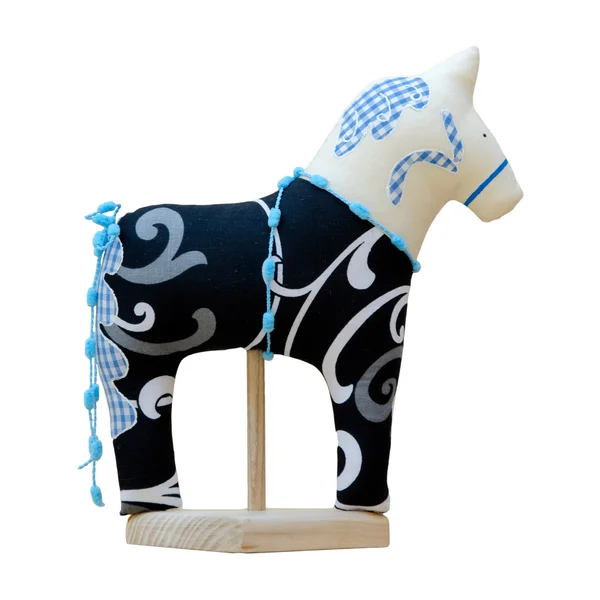 Hand made soft toy horse isolated on black with blue on the stan — Stock Photo, Image