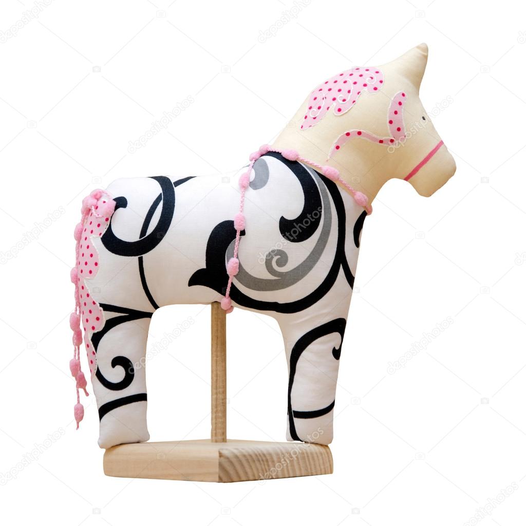 Hand made soft toy horse isolated on white with pink on the stan