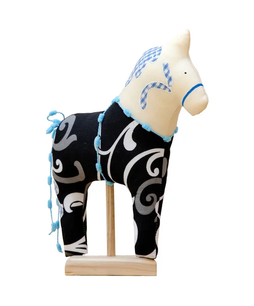 Hand made soft toy horse isolated on black with blue on the stan — Stock Photo, Image