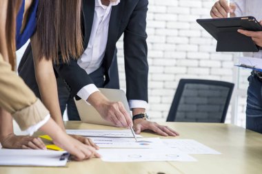 İş adamları, ofiste elde ettikleri başarıdan sonra liderlerini alkışlıyor ve toplantıda belge ve fikir raporlarını, çalışma stratejisi konseptini tartışıyor.