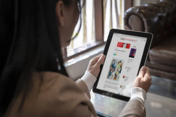 Kapanış konuşması yapan iş kadını haber modası veya internet sitesinde akıllı taplet, internet ağı konseptiyle makaleler okuyor