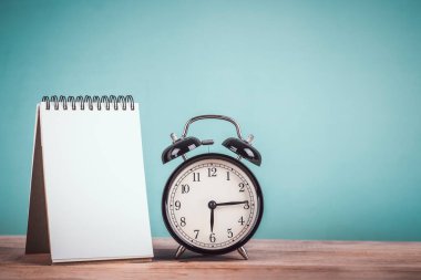 siyah retro alarm saati ve boş not kağıdı eski usul ahşap masa üzerindeki yazı için