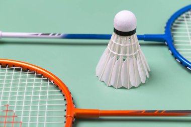Raket ve Shuttlecock badminton yeşil arka planda izole edilmiş, badminton spor konsepti