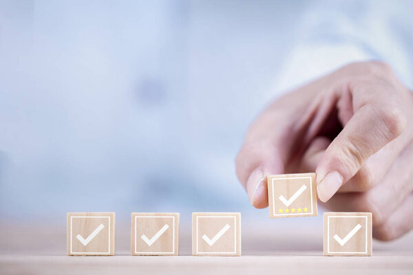 Контрольный список Обзор символ на деревянном блоке, бизнесмен выбирает галочку значок на деревянном кубе 5 звезд Удовлетворение клиентов лучше всего отлично и оценки концепции