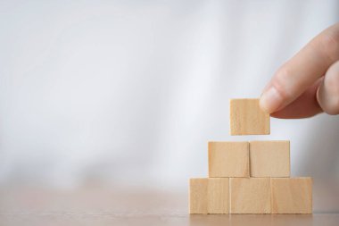 Hand choose square wooden blocks on table , blank wooden cubes on table with copy space , Hand  to hold the rectangular wooden block
