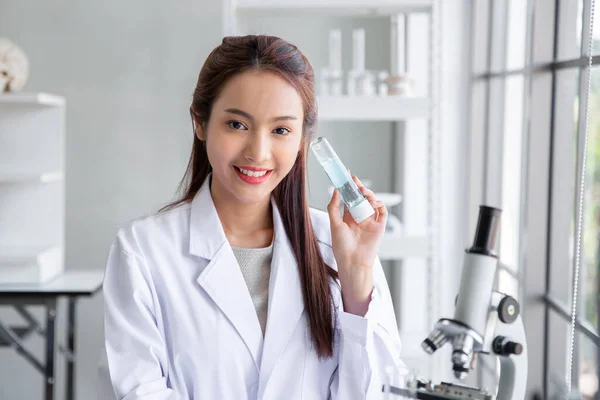 Attractive young asian scientist woman chemical sample in flask at laboratory , Asia medical woman working on test tubeanalysis and develop vaccine ,healthcare, research. Experimental science.