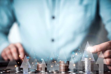 Businessman hand holding coin on stack coins with white arrows rising , Market finance and Investments growing with businessman investor , Save money and investment growth concept