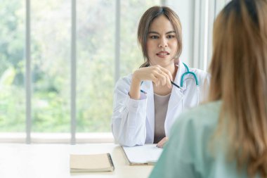 Smiling Asian woman pediatrician give advice to patients , Young asia female doctor consult female patient and checkup in hospital , healtcare and assistance concept