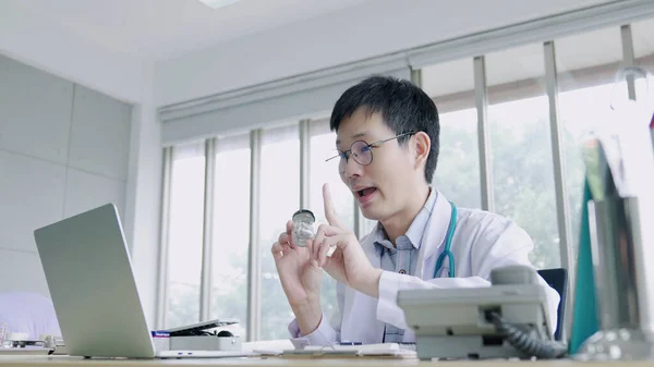 Asia man doctor consulting patient with sickness symptoms online via video call on laptop , Remote Medical Consultancy concept