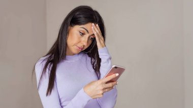 Güzel, üzgün, endişeli, mutsuz kadın. Akıllı telefonuna bakıyor.