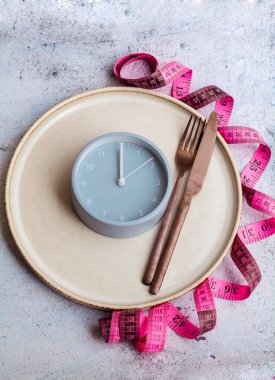 Çatal bıçak, ölçü ve çalar saat. Diyet konsepti. Yemek kontrolü. Üst görünüm