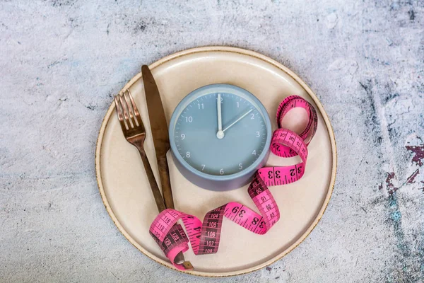 Çatal bıçak, ölçü ve çalar saat. Diyet konsepti. Yemek kontrolü. Üst görünüm