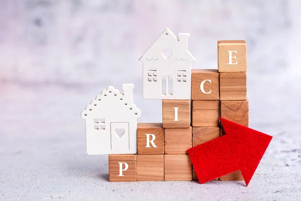 価格の単語と赤い矢印を持つ木造住宅や木製のキューブのモデル プロパティ値の概念を増加 — ストック写真