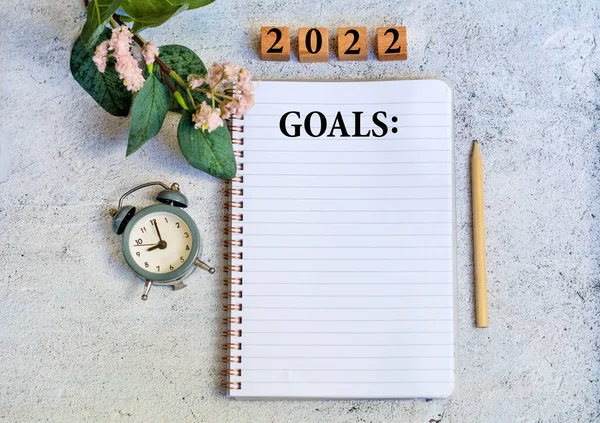 Yeni 2022 yılı hedefleri ve ofis aksesuarları ile not defterini planlamak. İş konsepti. Üst görünüm