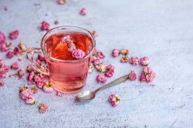 Rose buds tea in a glass cup . Tea made from tea rose petals