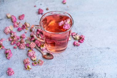 Rose buds tea in a glass cup . Tea made from tea rose petals