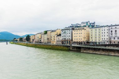Salzburg, Avusturya - 10 Temmuz 2019: tarihi Eski Şehir binalarıyla turkuaz hanı nehri