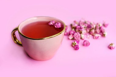 Gri desenli arka planda gül tomurcukları olan çiçek çayı. Kurumuş çay gülleri çiçekleri.