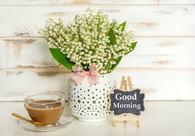 Vadideki zambak, bir fincan kahve ve günaydın mesajı.