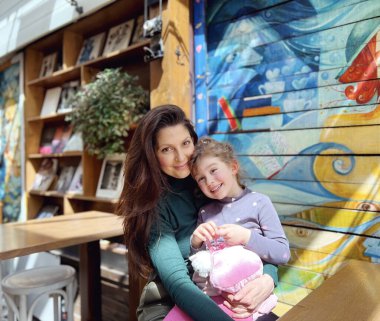 Küçük kızını kucaklayan mutlu anne. Mutlu aile portresi.