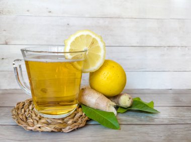 Kombucha tea with lemon and ginger in glass cup clipart