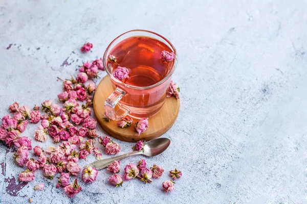 Rose buds tea in a glass cup . Tea made from tea rose petals