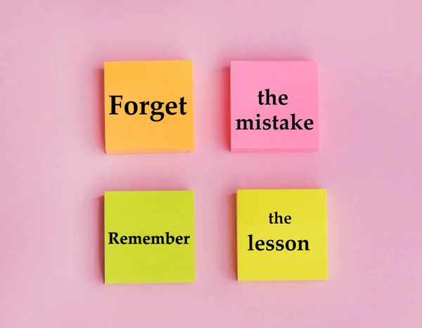 Inspirational motivation quote forget the mistake remember the lesson on sticky notes on pink background