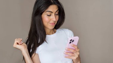 Beautiful young smiling brunette woman using mobile phone . Woman looking her phone