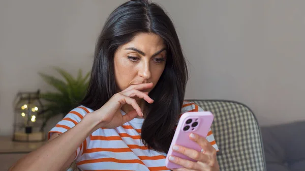 Beautiful Sad ,Worried Unhappy Woman Looking at her Smartphone