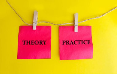 Theory and practice words . Wooden clothespins with red sticky notes with Words theory and practice on yellow background