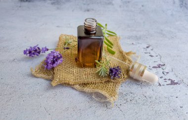 Lavanta yağı şişesi ve ahşap arka planda taze lavanta. 