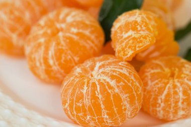 Mandalinaları yakın plan bir tabakta soyulmuş. Seçici odaklanma. Noel kompozisyonu.